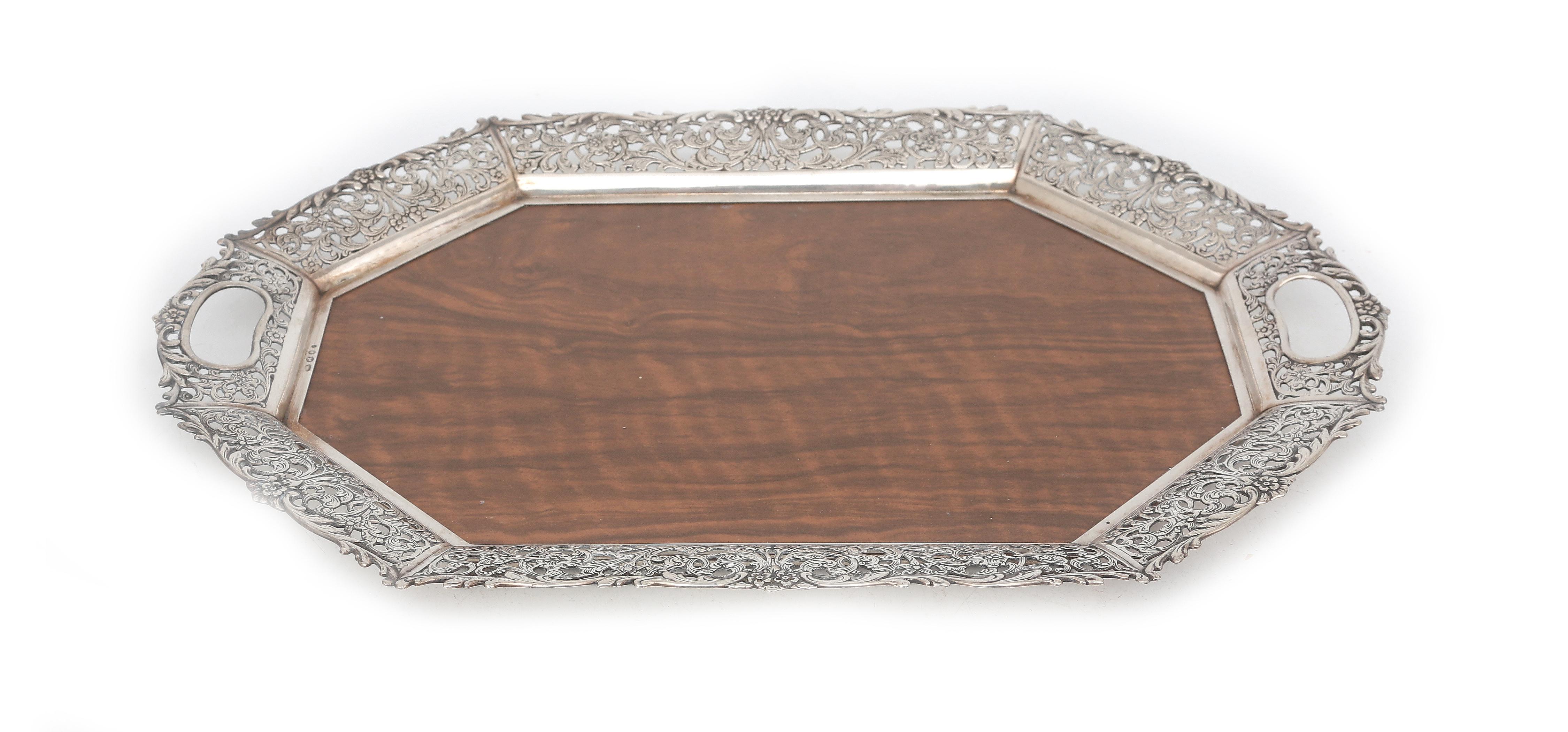 A plastic tray with pierced silver border.
