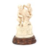 A carved ivory okimono of man carrying an infant, circa 1920.