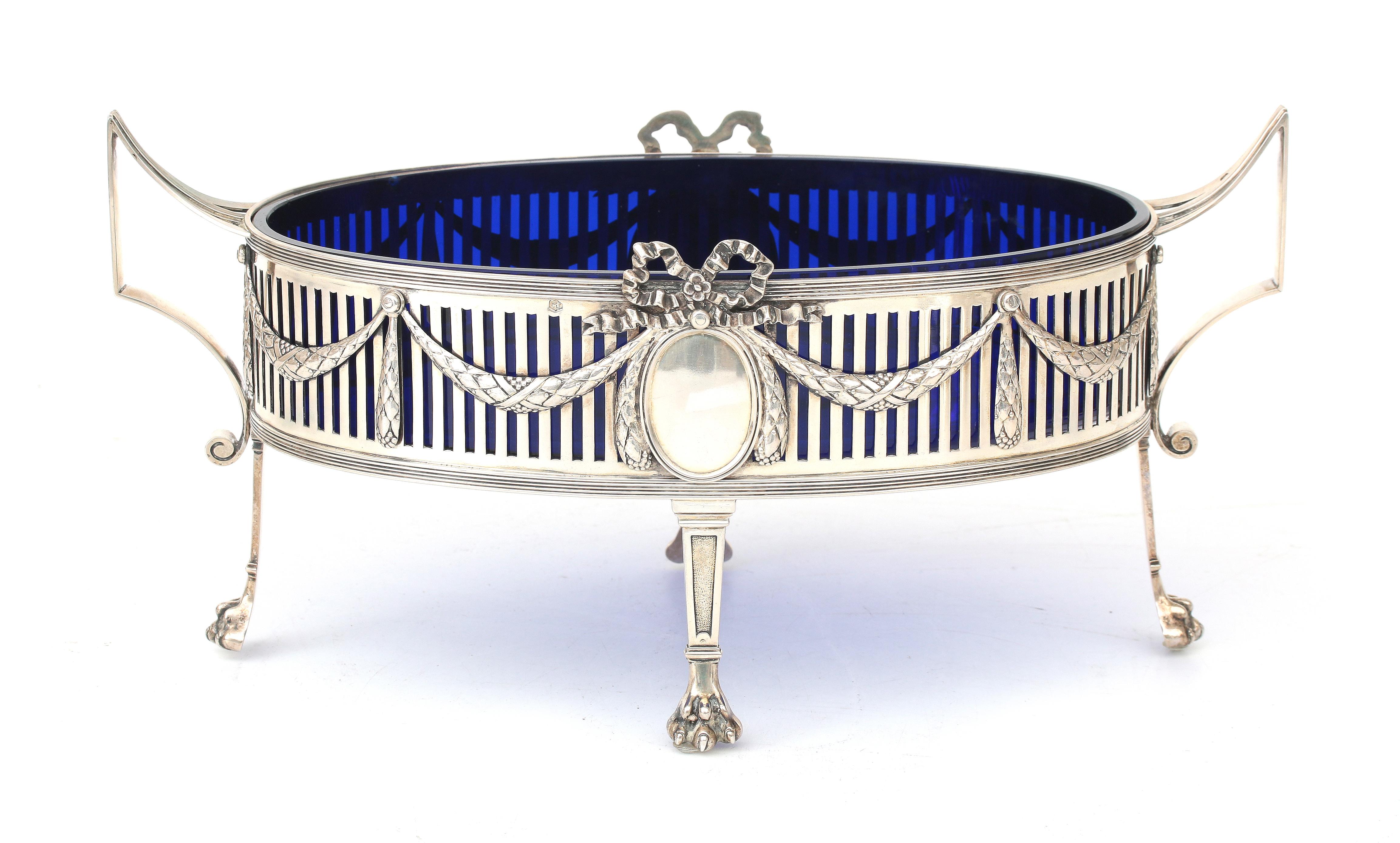 A pierced silver jardinière with cobalt blue glass liner.