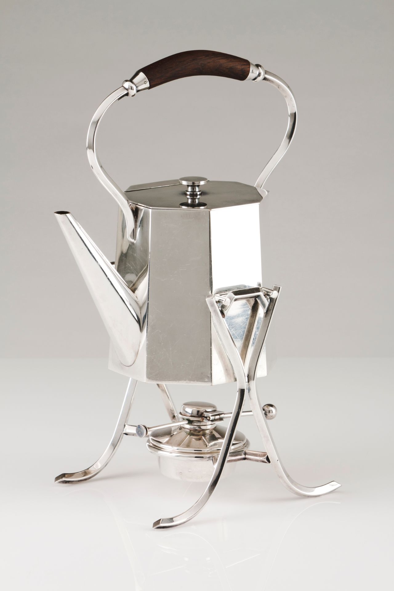 A kettle on stand and burnerSilvered metal Faceted body, turned wooden element to handle