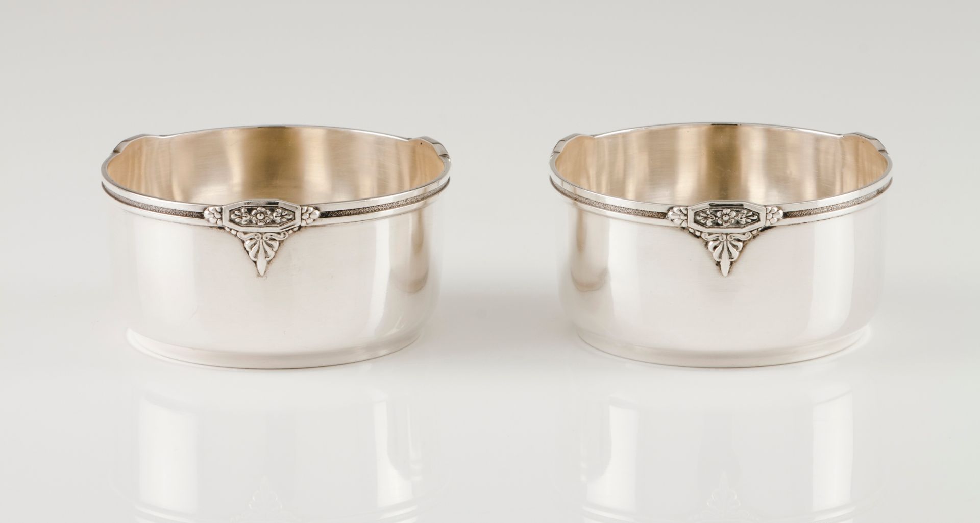 A pair of finger bowlsPortuguese silver Plain body of engraved lip frieze with applied floral de