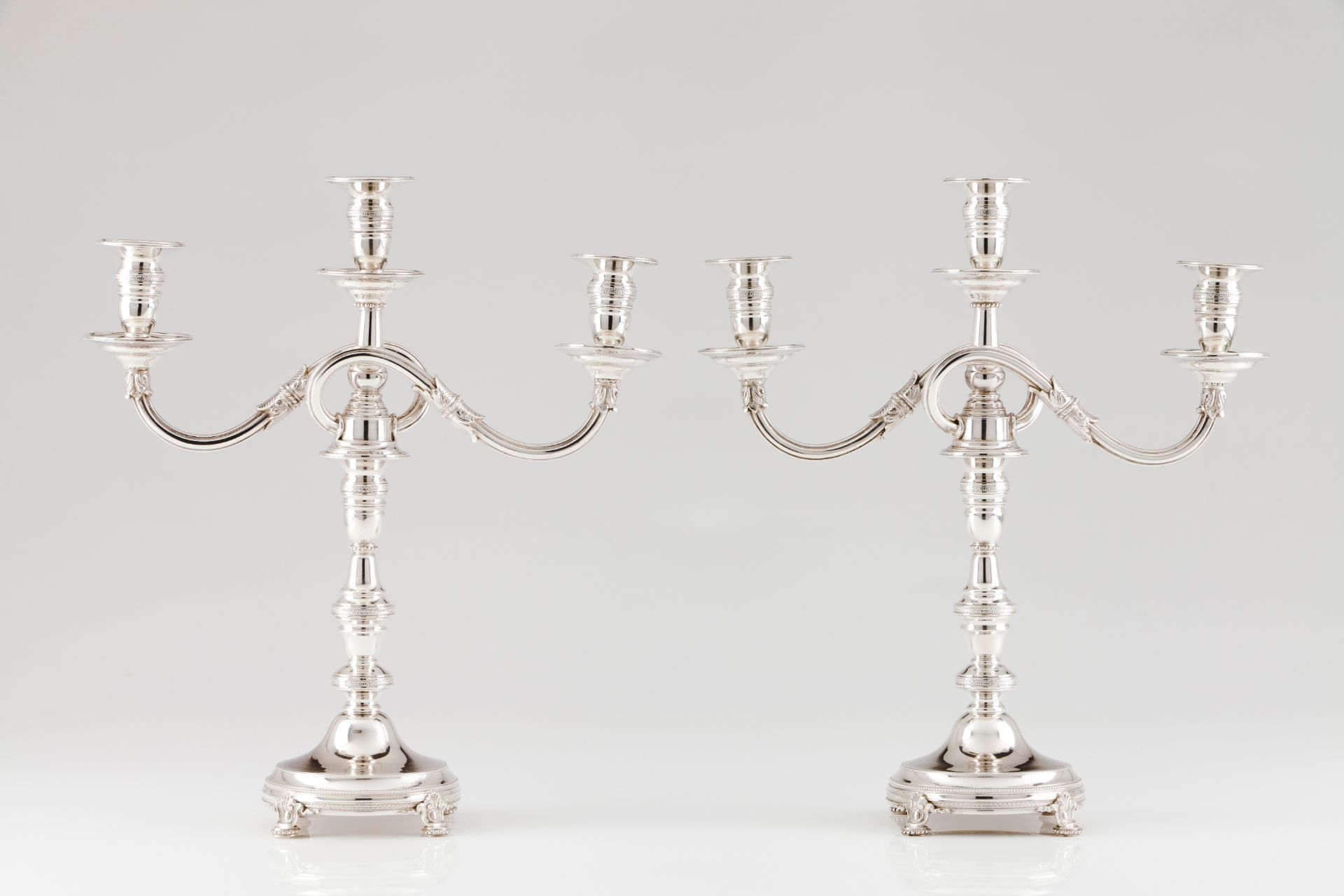 A pair of three branch candelabraPortuguese silver Turned shaft of engraved friezes Grooved and