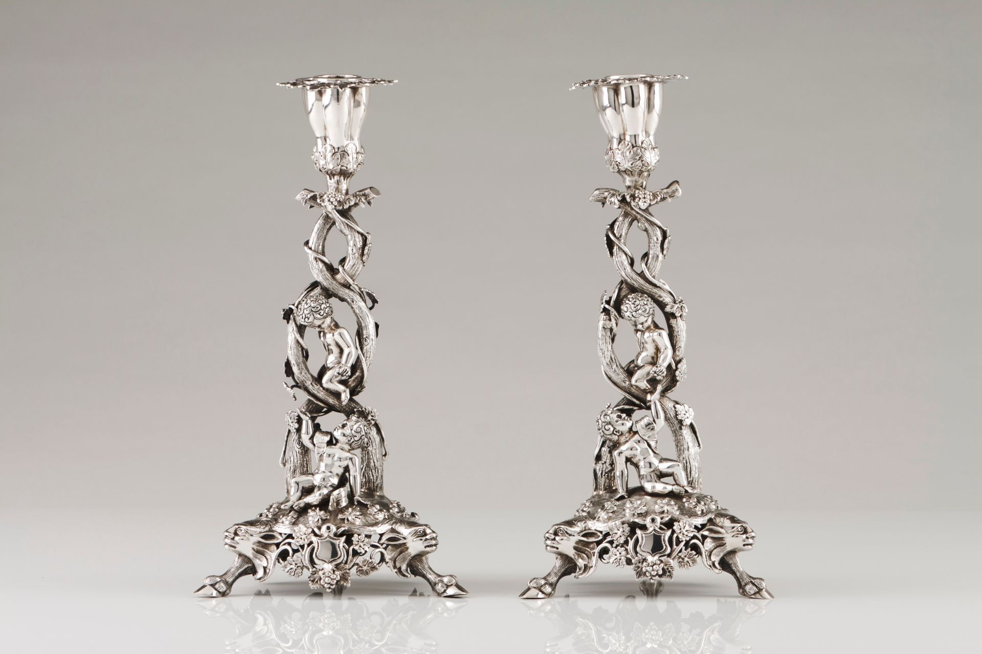 An unusual pair of candlestandsPortuguese silver, 19th century Profuse Romantic era decoration o