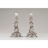 An unusual pair of candlestandsPortuguese silver, 19th century Profuse Romantic era decoration o