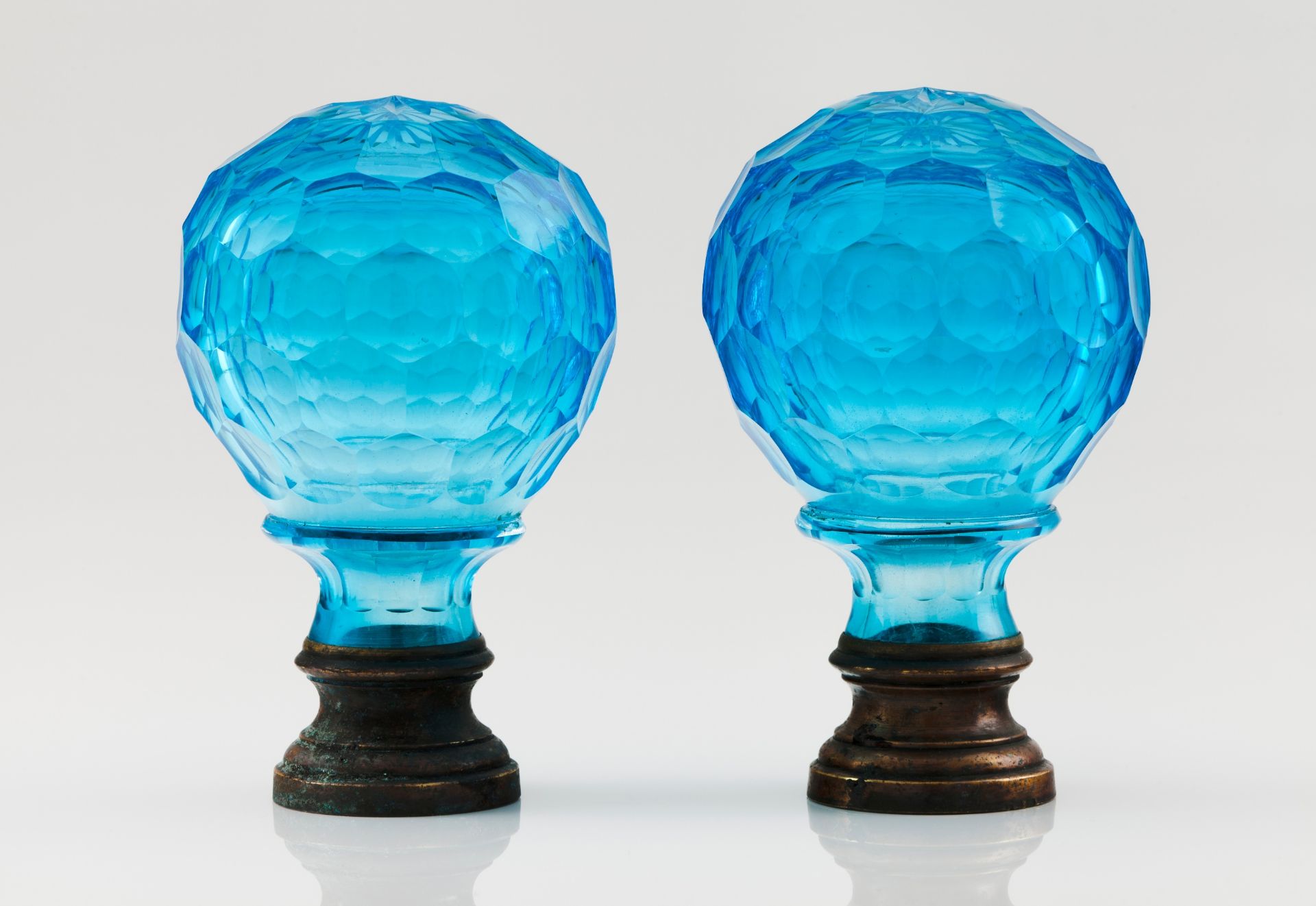 A pair of pine conesBlue cut glass Metal fittings