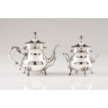 A small teapot and sugar bowlPortuguese silver Plain body on four scroll feet and volute handles