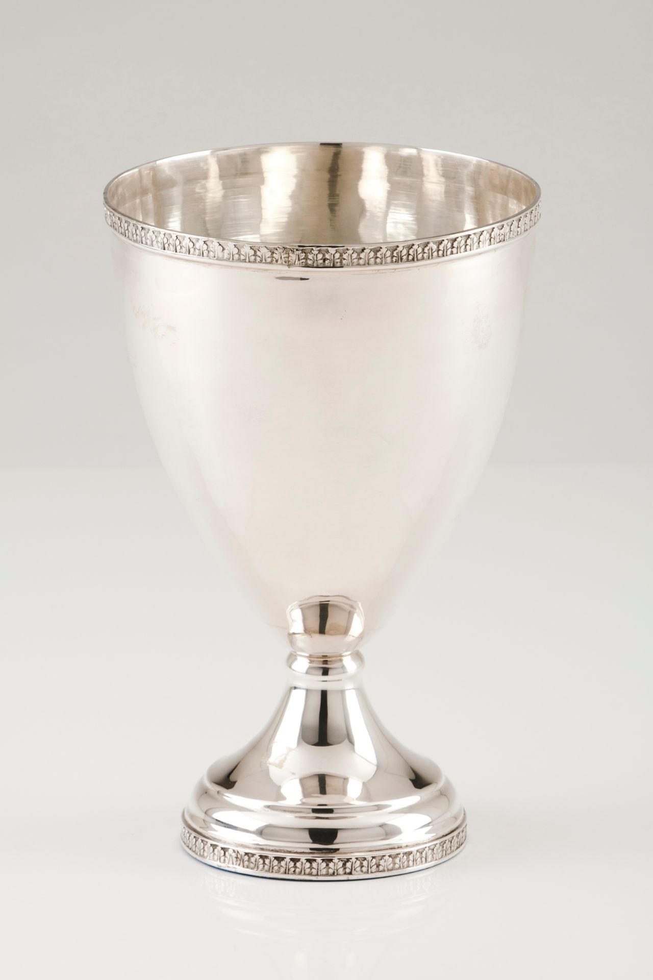 A bowlPortuguese silver Large chalice shaped plain body of engraved foliage bands to top and foo