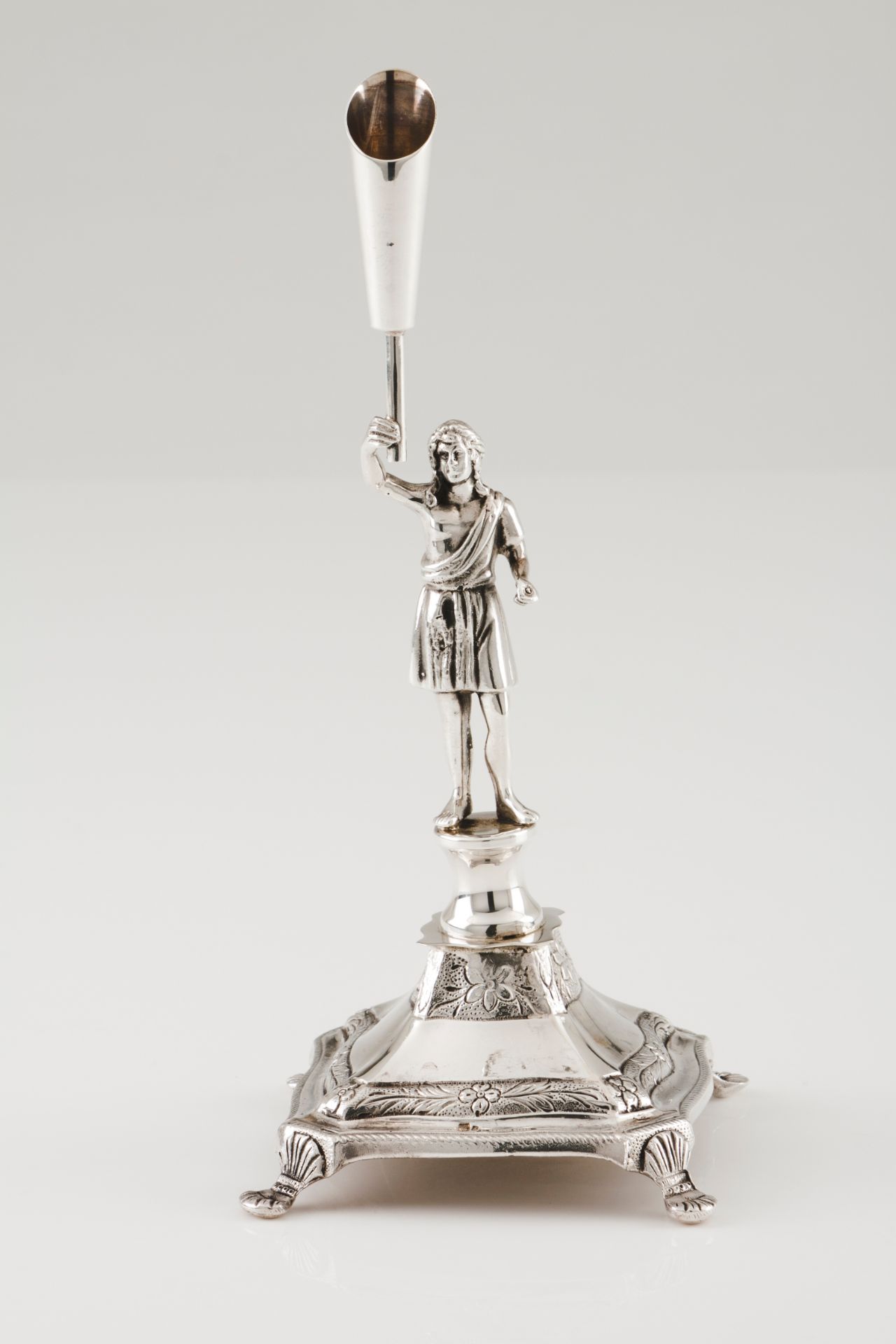 A toothpick holderPortuguese silver Classical male figure holding torch on a 4 shell feet foliag