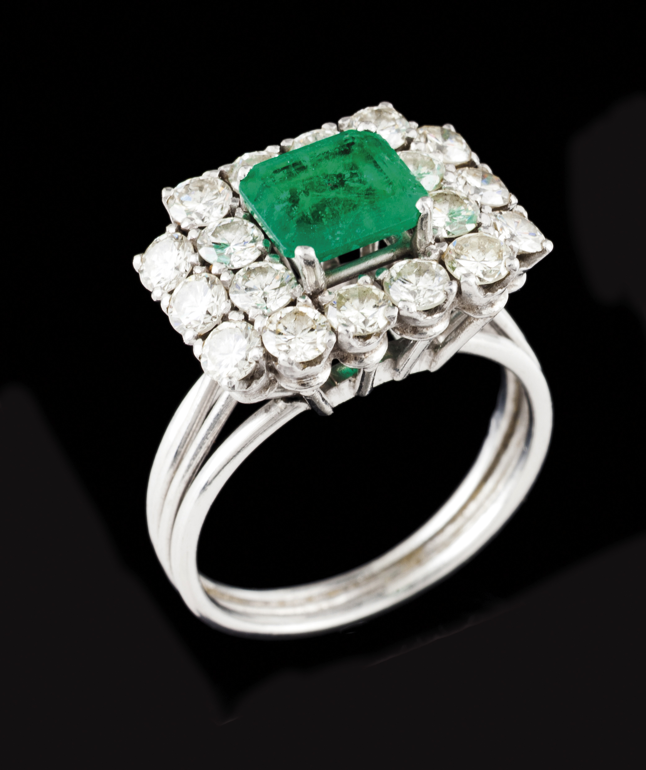 A ringPlatinum Set with one emerald cut emerald (ca. 0.85) and 18 brilliant cut diamonds