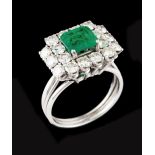 A ringPlatinum Set with one emerald cut emerald (ca. 0.85) and 18 brilliant cut diamonds