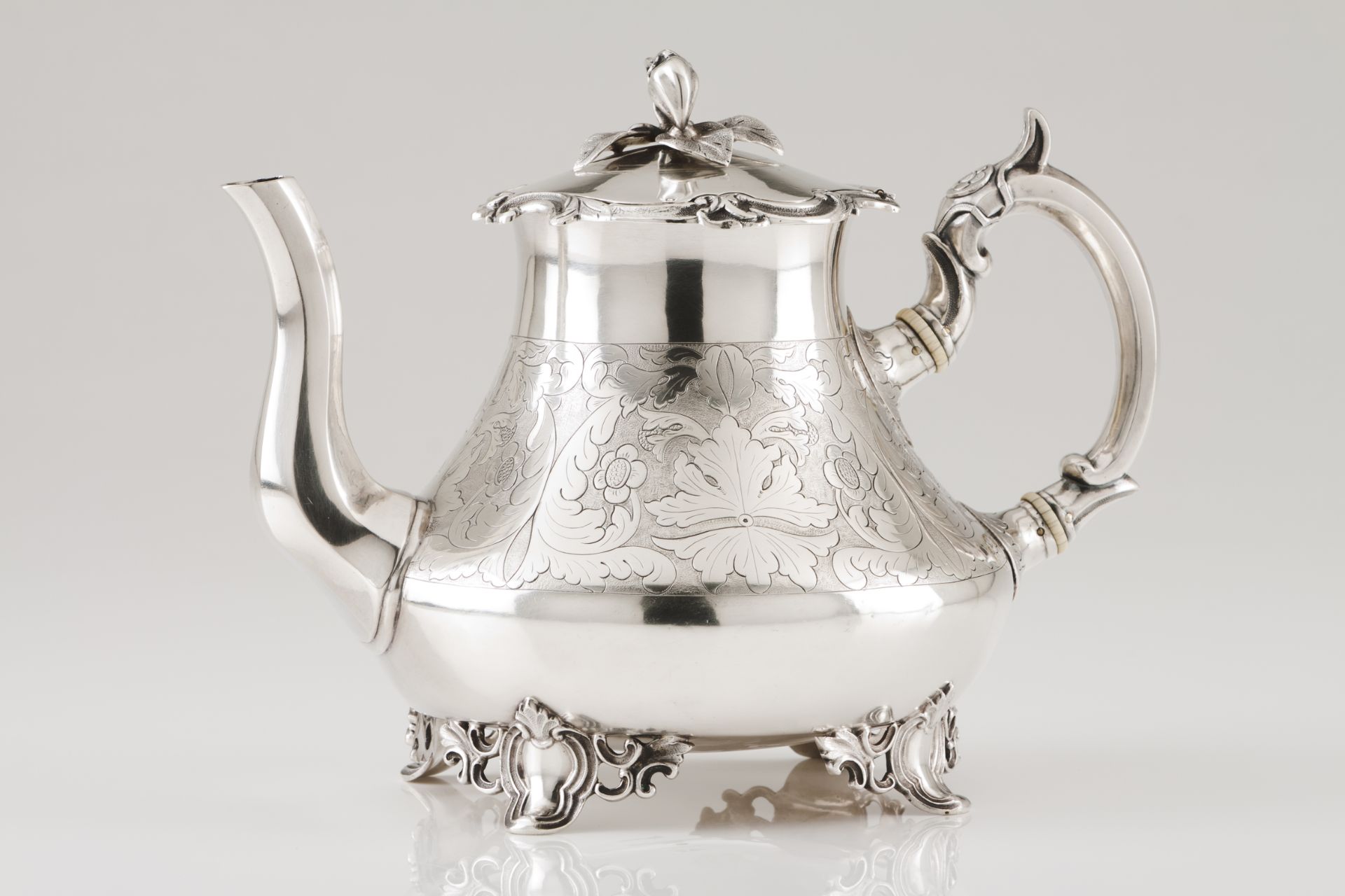 An unusual teapotPortuguese silver Bell shaped body of wide floral engraved band; faceted spout,