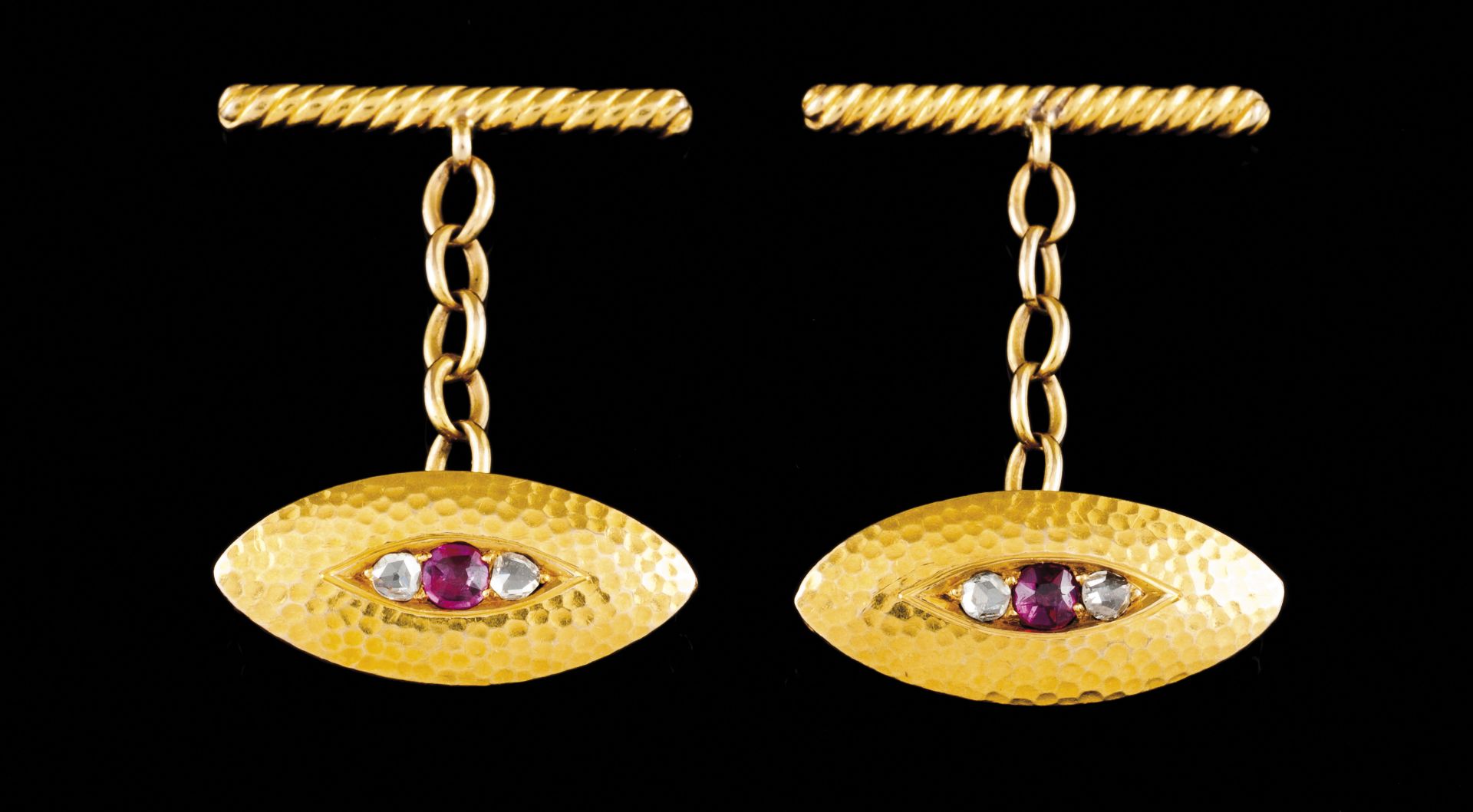 A pair of cufflinksPortuguese gold Hammered elliptic shaped set with ruby and crowned rose cut