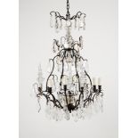 An eight branch chandelierPatinated metal With cut and molded crystal drops Late 19th century, early
