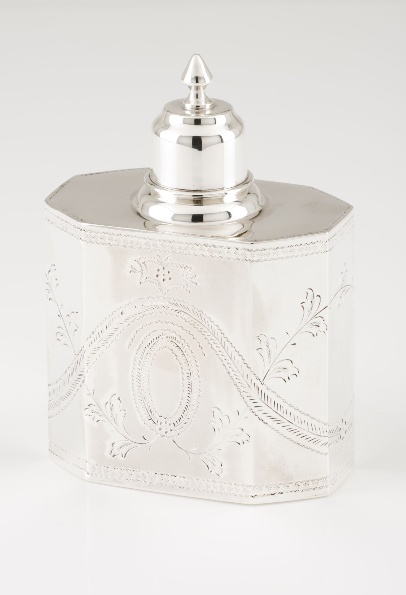 A tea caddyPortuguese silver D.Maria style decoration Faceted, engraved and chiselled body of