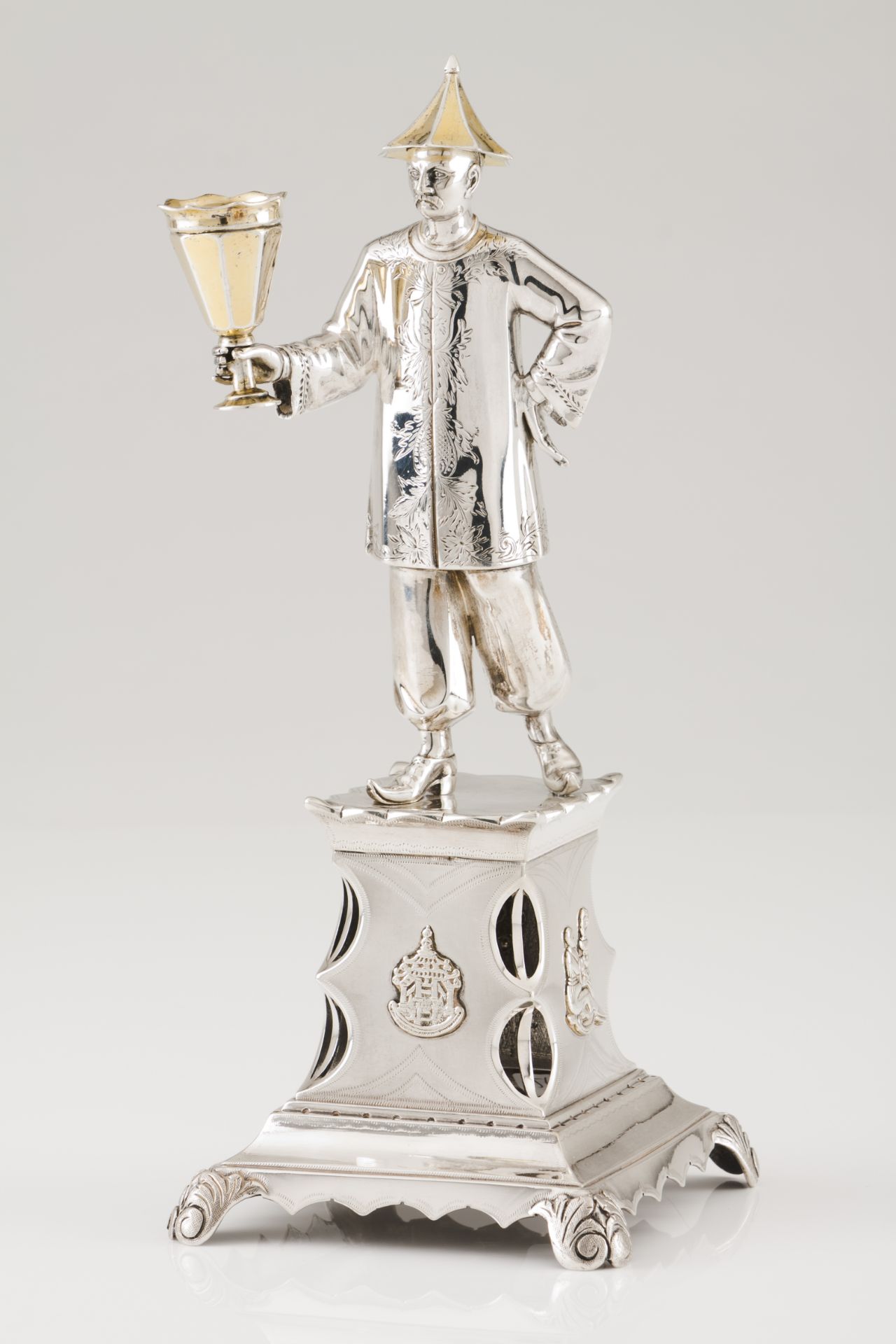 A toothpick holderPortuguese silver, 19th century Chinese figure holding bowl on a raised sand