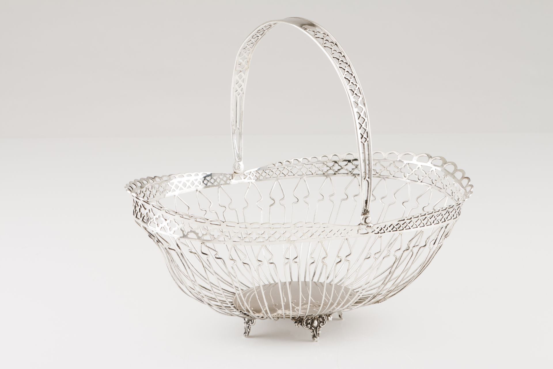 An articulated handle basketPortuguese silver Oval base, thread mesh basket and pierced gallery