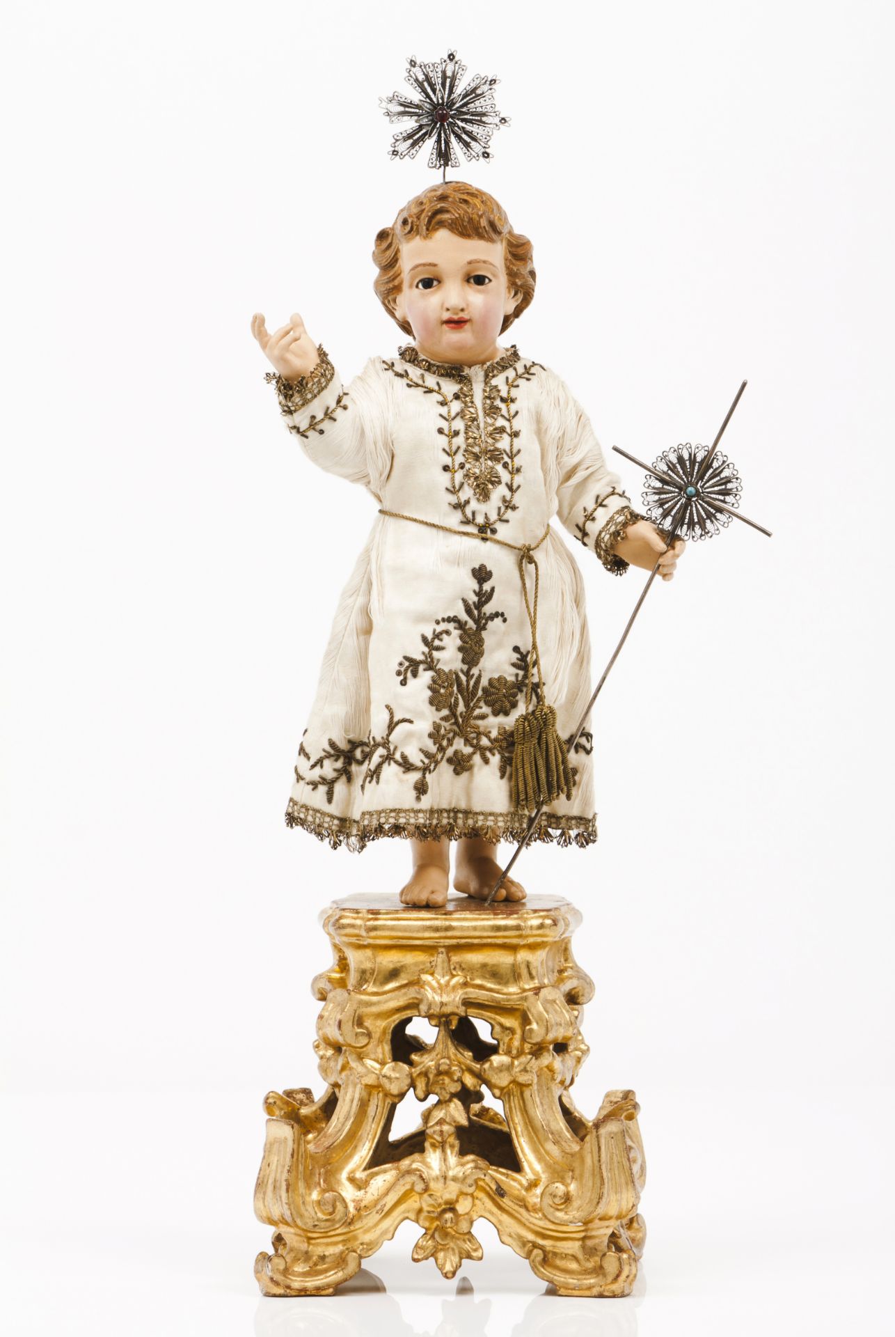 The Child JesusCarved and polychrome wood Metal thread embroidered silk attire, silver cross and