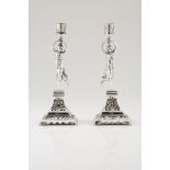 A pair of candle standsPortuguese silver, 19th century Female figure with head basket on a raised
