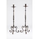 A pair of candle holdersWrought iron Moulded decoration and on three feet Portugal, 19th