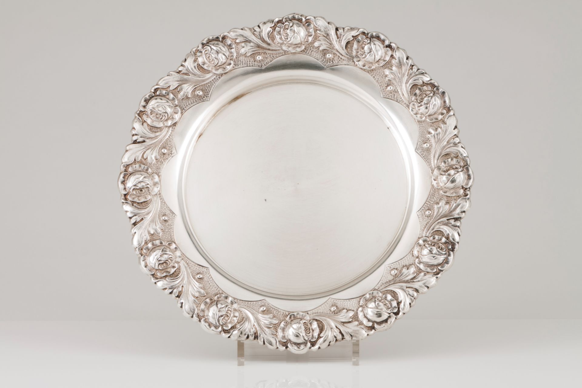 A salverPortuguese silver Plain centre and engraved lip of raised roses and foliage decoration On