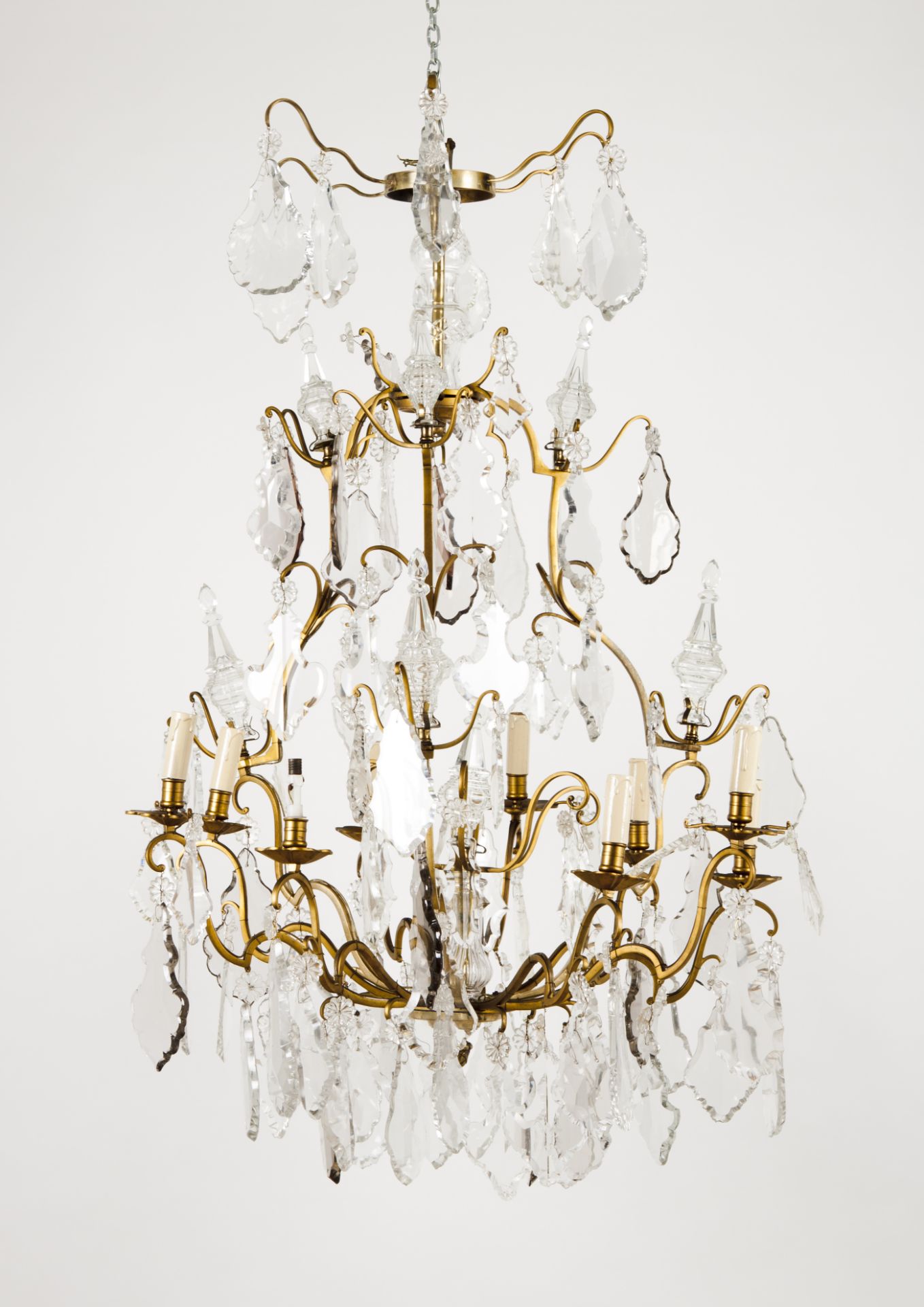 A nine branch chandelierPatinated metal With cut and molded crystal drops Late 19th century, early