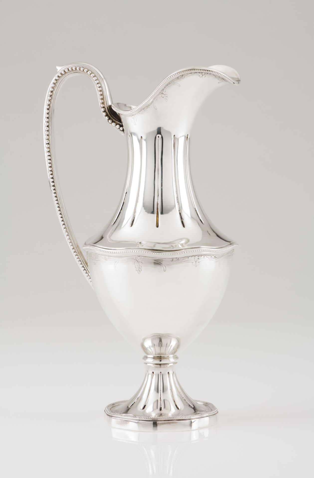 A wine jugPortuguese silver Lip and foot of grooved decoration and beaded frieze Undulating body