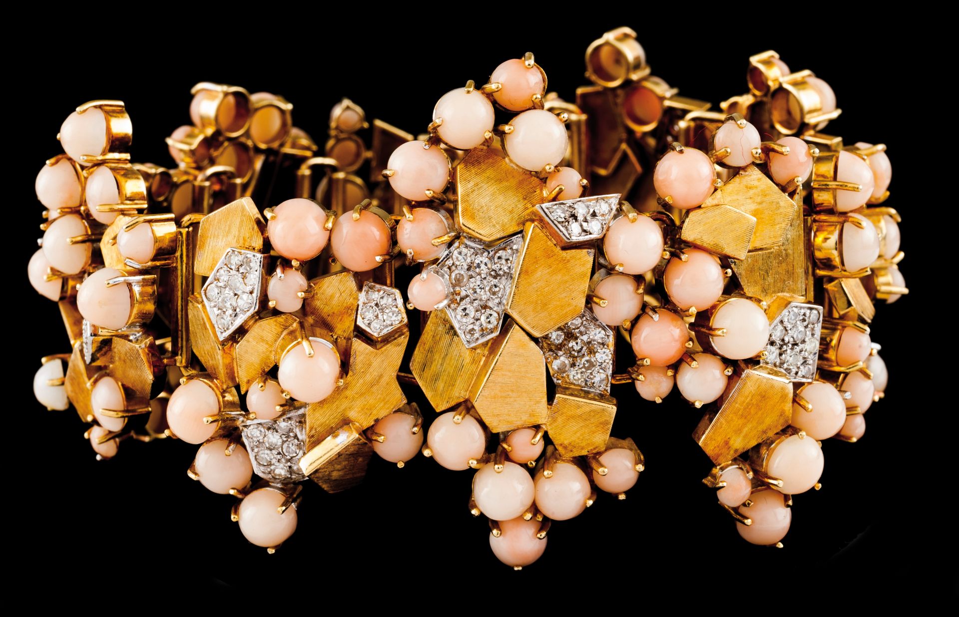 A braceletBicoloured gold Articulated links and asymmetric elements set with cabochon cut corals and
