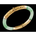 A braceletGold and jade Hinged jade elements of applied gold details with raised oriental motifs