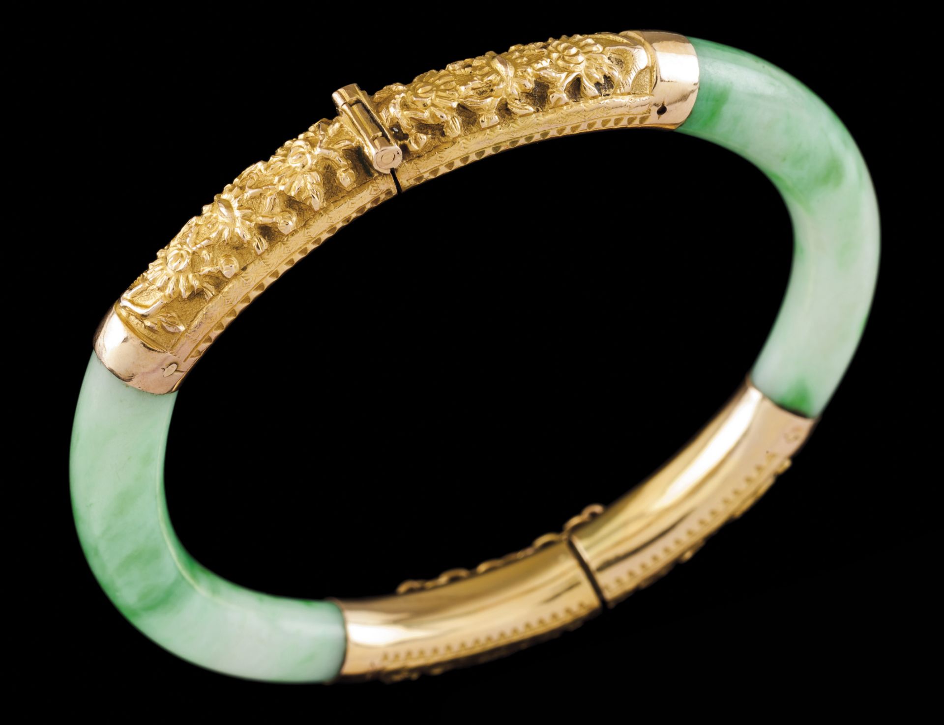 A braceletGold and jade Hinged jade elements of applied gold details with raised oriental motifs