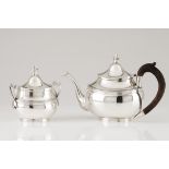 A teapot and sugar bowlPortuguese silver Oval shaped body of engraved frieze and flattened urn lid