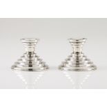 A pair of Art Deco low candlestandsPortuguese silver Stepped decoration of beaded frieze to base