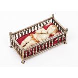 A reclining Baby JesusIndo-Portuguese ivory sculpture Gold and coral decorative elements Silver