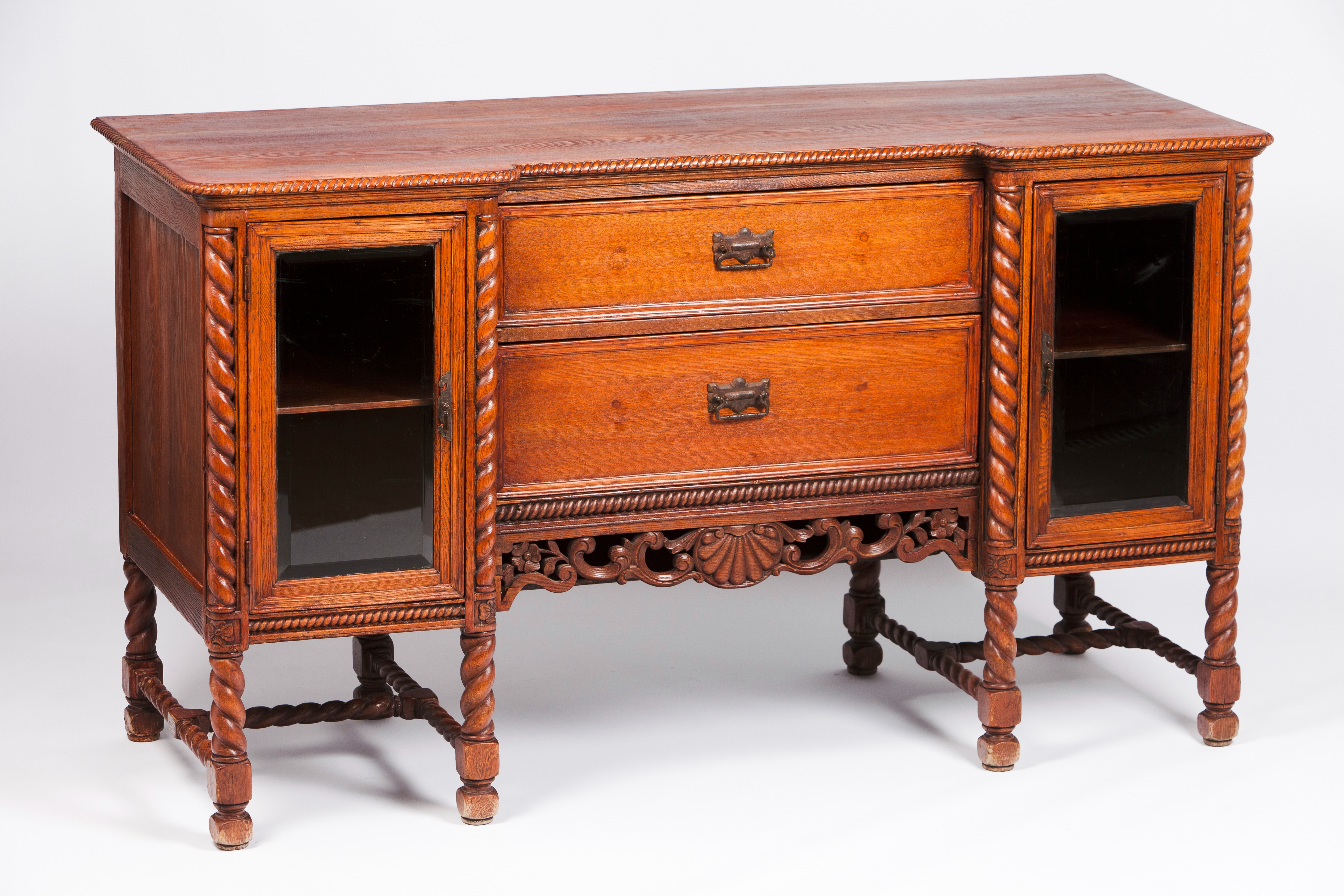 A colonial sideboardTeak Two glazed side doors and two central drawers Carved barley twist and