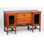 A colonial sideboardTeak Two glazed side doors and two central drawers Carved barley twist and