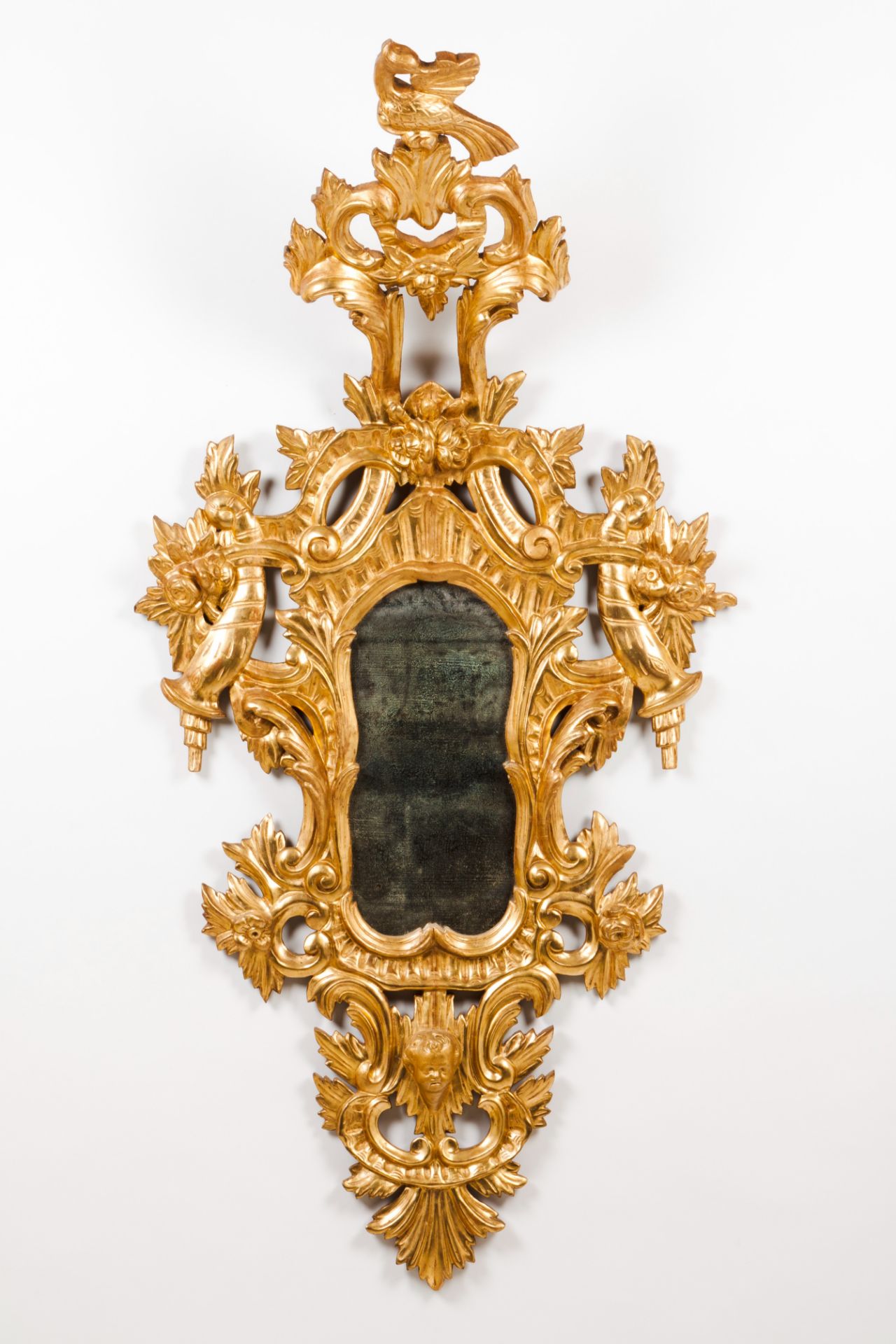 A wall mirrorCarved and gilt wood Foliage and angel's head decoration Spain, 19th century160x78 cm