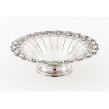 A footed fruit bowlSilver Grooved body, raised and engraved lip of floral and foliage decoration