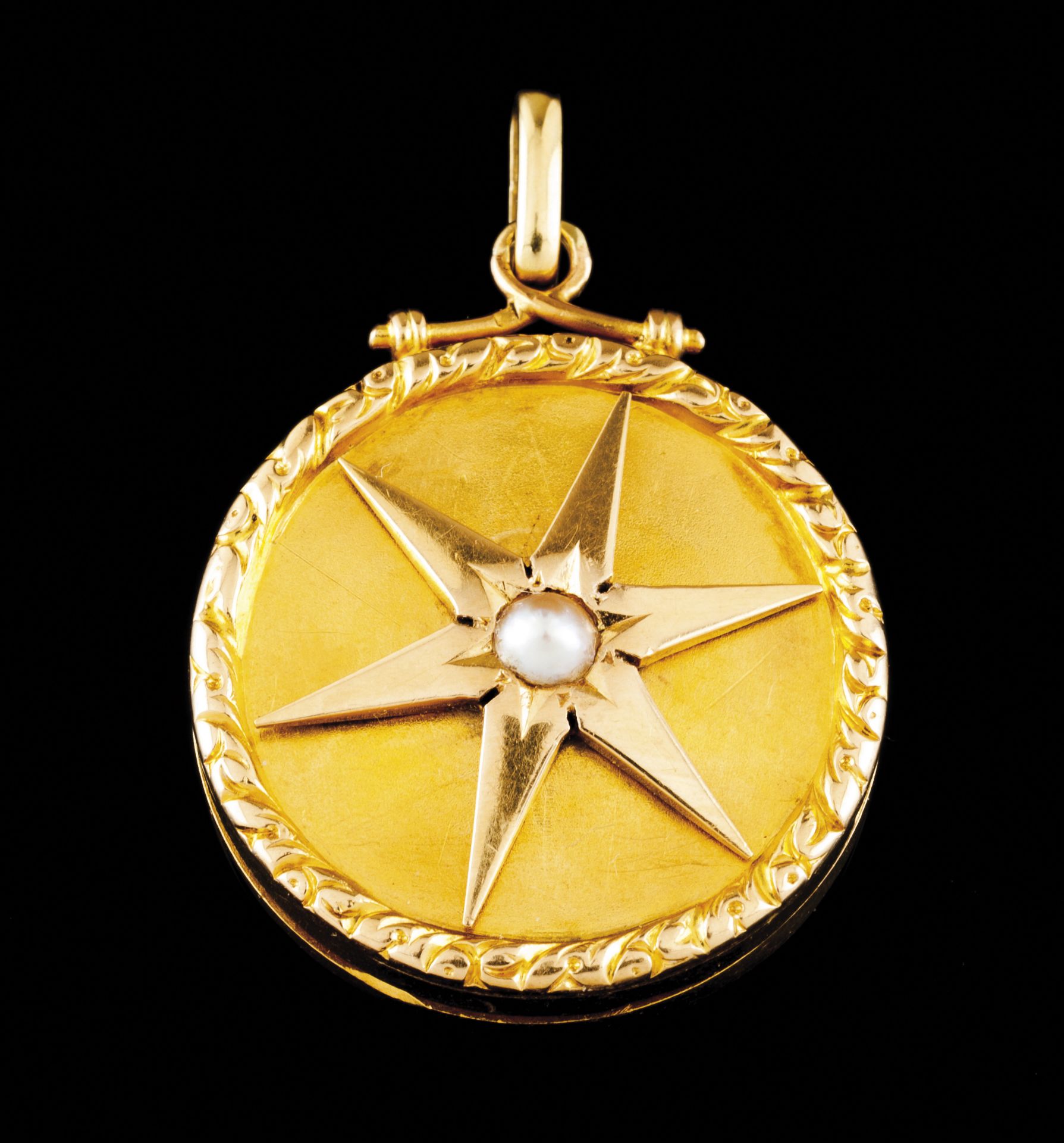 A reliquary pendantGold Circular shaped, plain front of relief frame and applied rotating star set