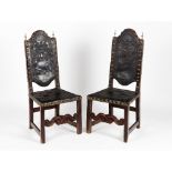 A pair of chairsWalnut Embossed leather back and seats fixed with yellow metal tacks Heraldic shield