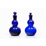 A group of four bottles and stoppers Gourd-shaped blue glass Reliefs and spiralled decoration