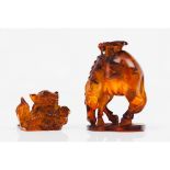 A set of two sculpturesA horse and a Foo dog Paste simulating amber 20th centuryHeight: 14 cm (