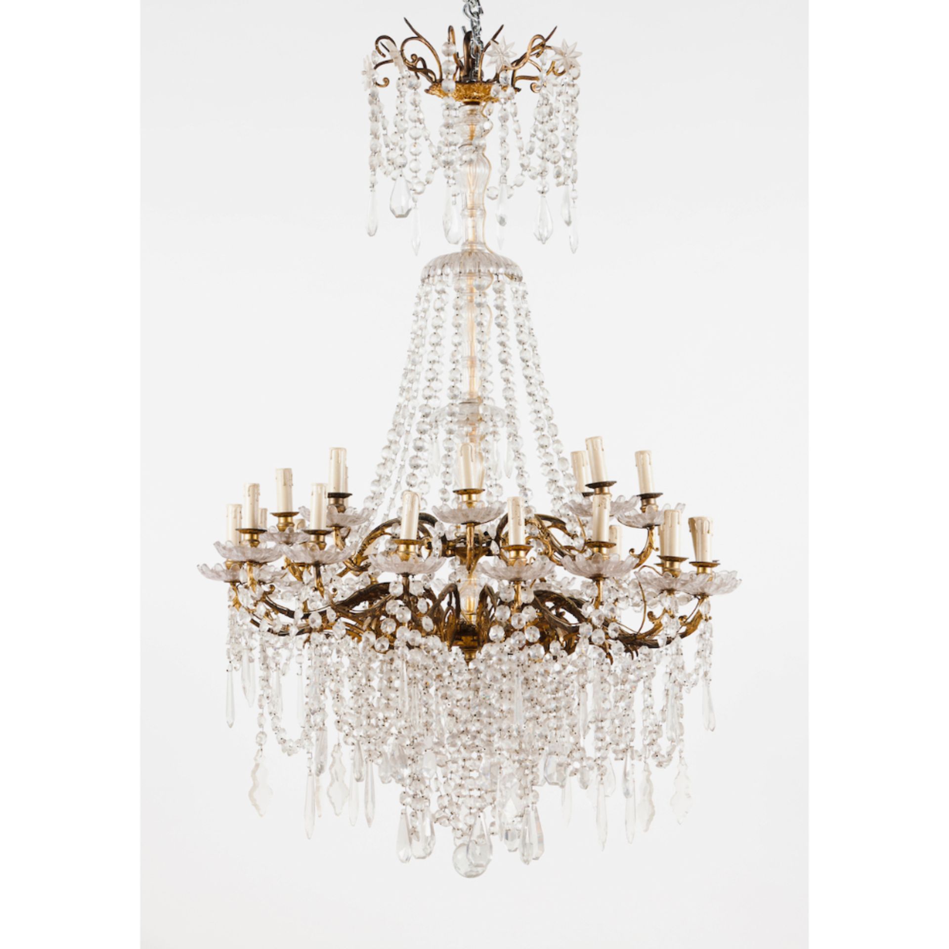 A twenty branch chandelierGlass and crystal drops Yellow metal frame Europe, 19th century140x90 cm