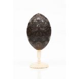 A coconut shell or similarProfuse foliage decoration Carved ivory base Possibly South-American, 19th