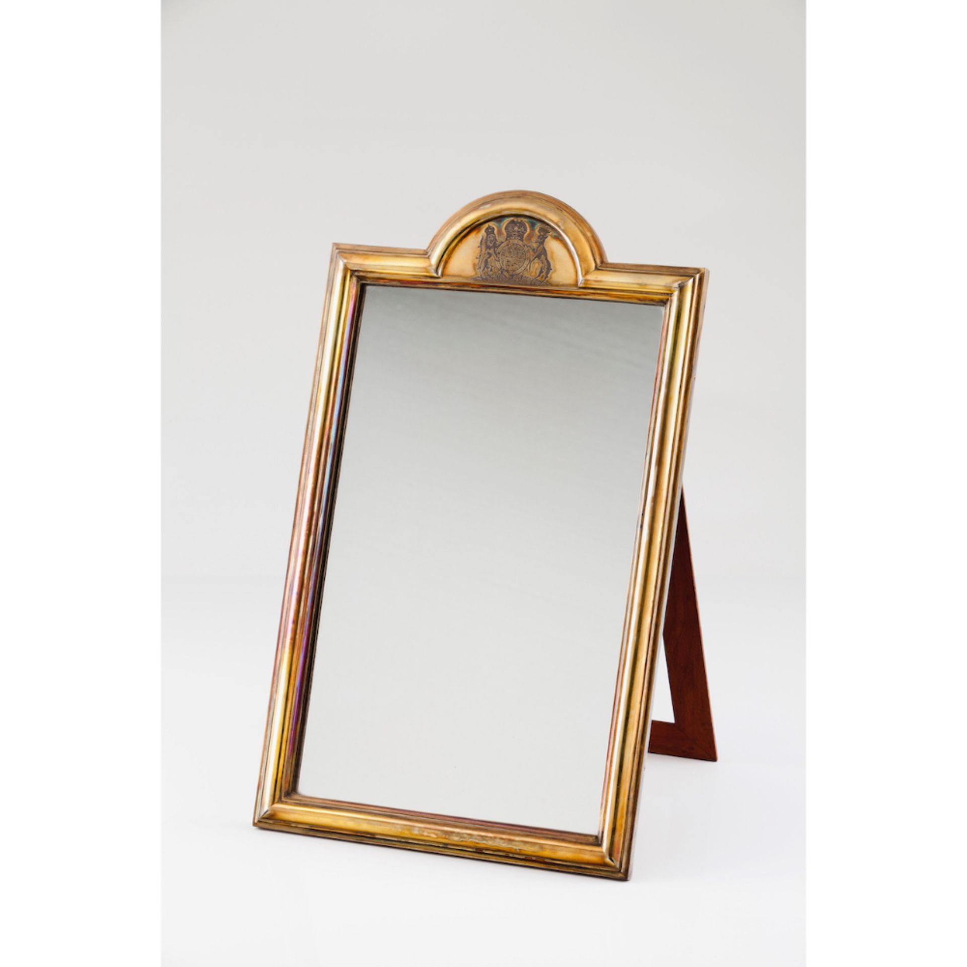 A tabletop mirrorEnglish silver and wood Topped by Crowned British Royal heraldic shield English