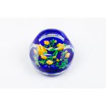 A paperweightFaceted glass paste Inner floral decoration on a dark blue ground 20th centuryDiam.: