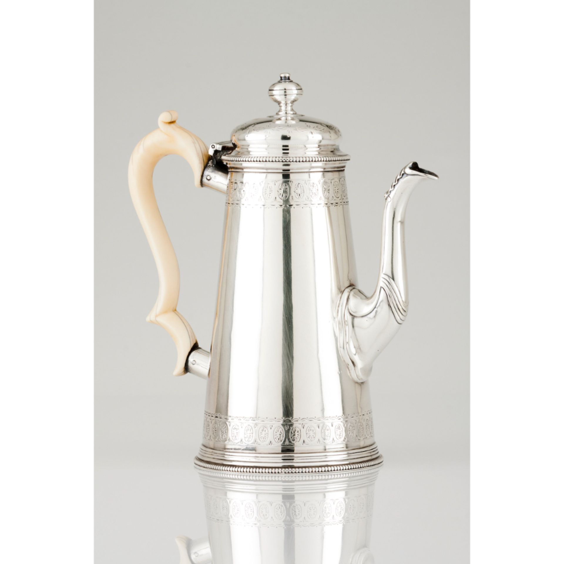 A coffee potEnglish silver, 19th century Engraved neoclassical decoration Spout of leaf finial Ivory