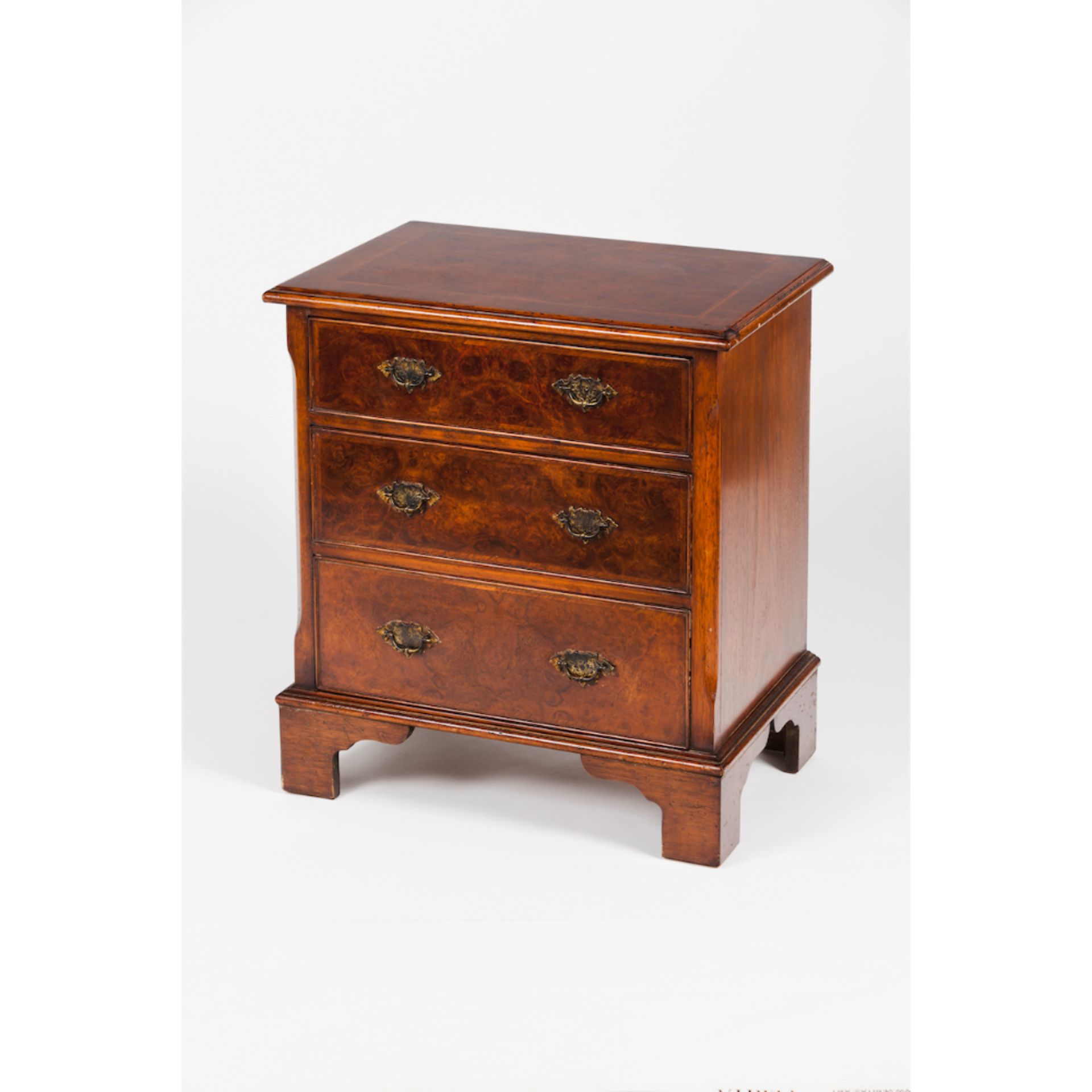 A small George III style chest of drawersMahogany Burr walnut veneer Three drawers and metal