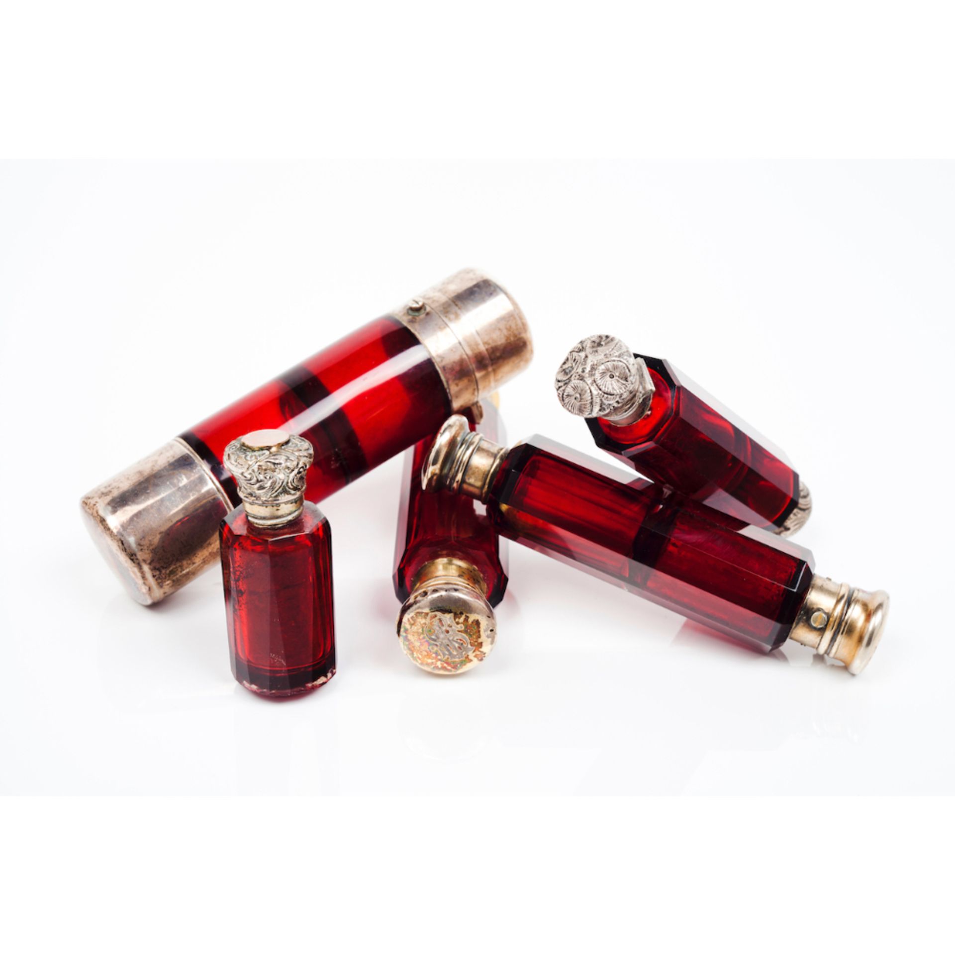 A set of five perfume bottles with stoppersRed faceted glass Silver and metal stoppers 19th