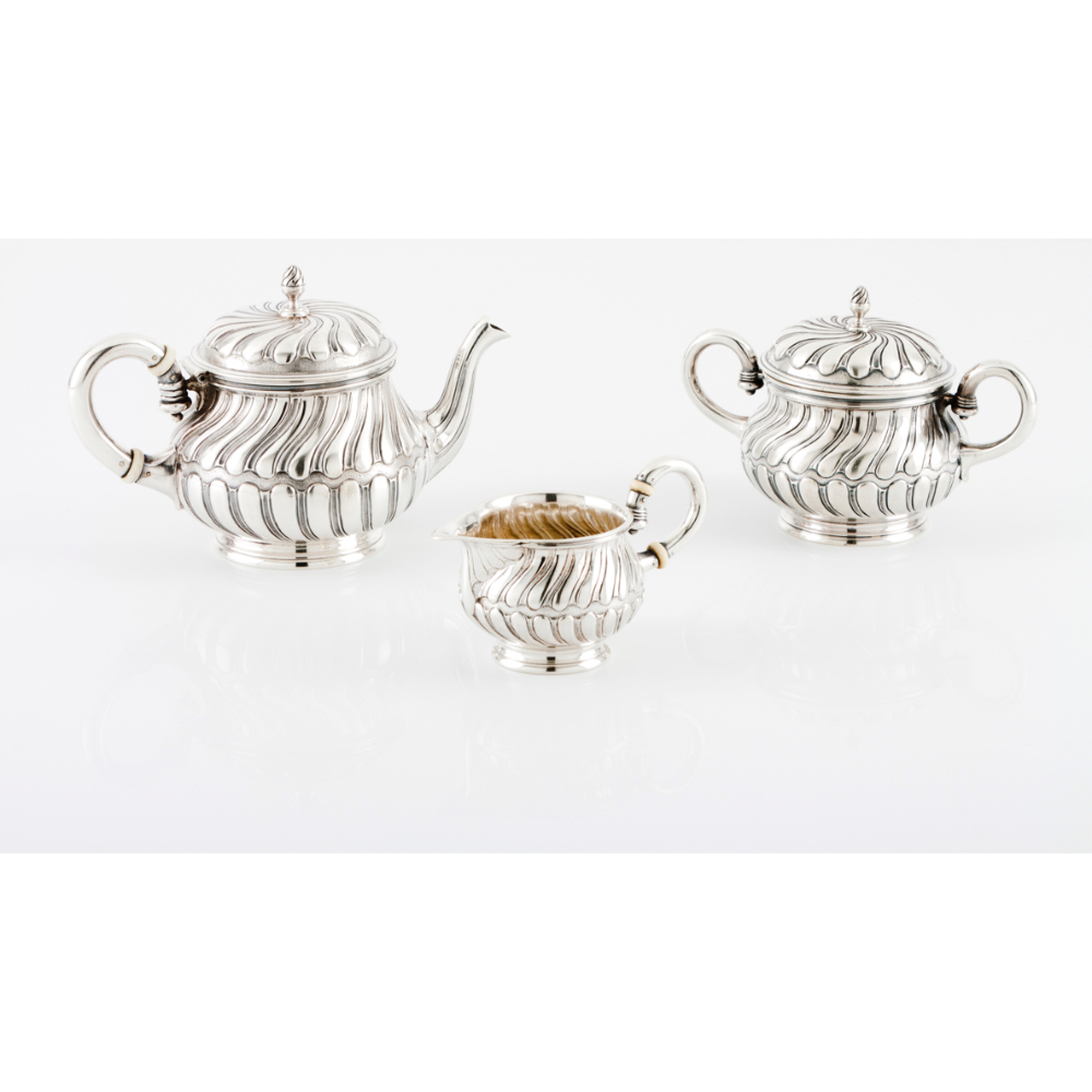 A tea set LEITÂO & IRMÂOTeapot, milk jug and sugar bowl Portuguese silver Reliefs and spiralled