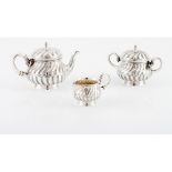 A tea set LEITÂO & IRMÂOTeapot, milk jug and sugar bowl Portuguese silver Reliefs and spiralled