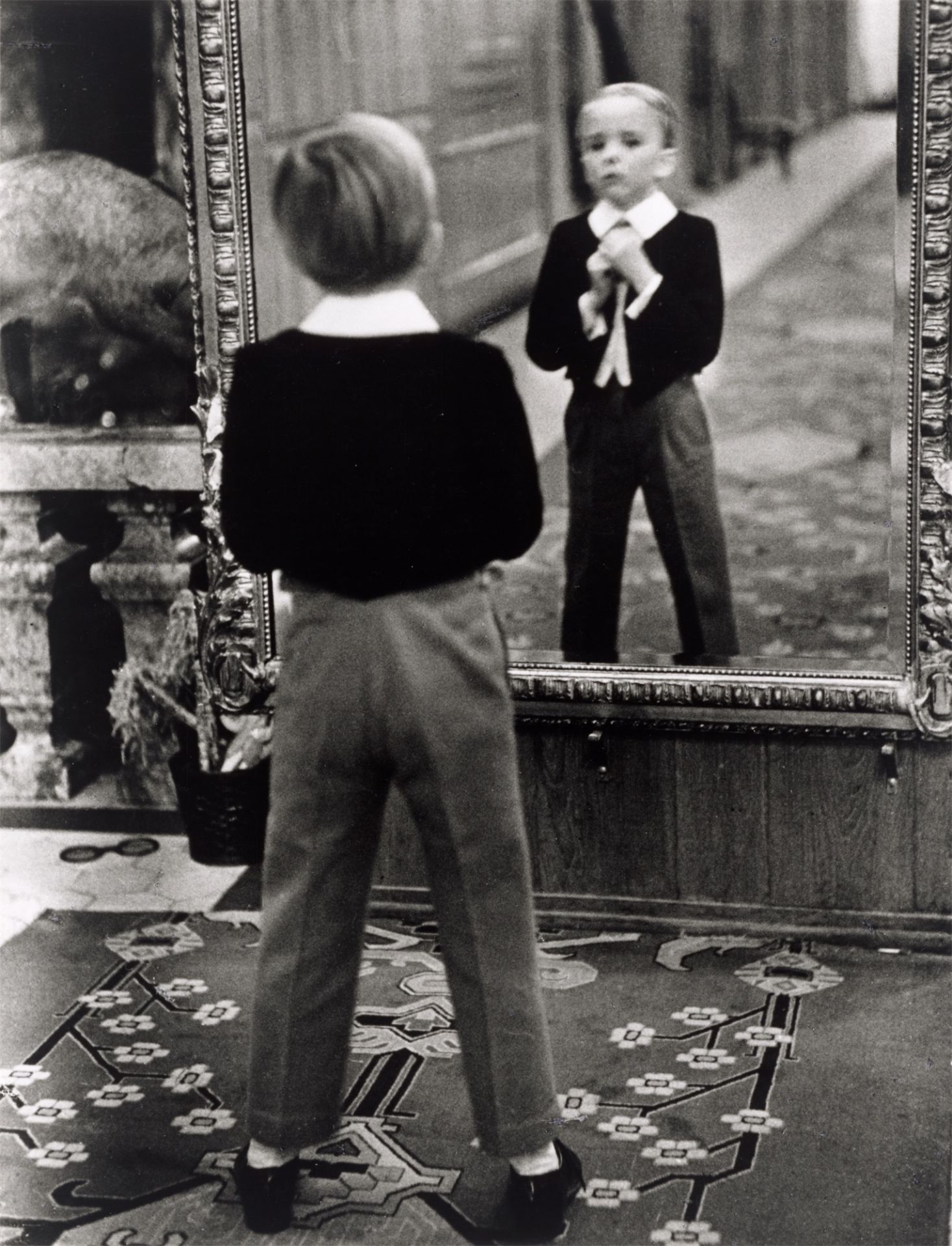 Alfred Eisenstaedt. „Young English man looking in the mirror of the Grand Hotel in St. Moritz“. 1932